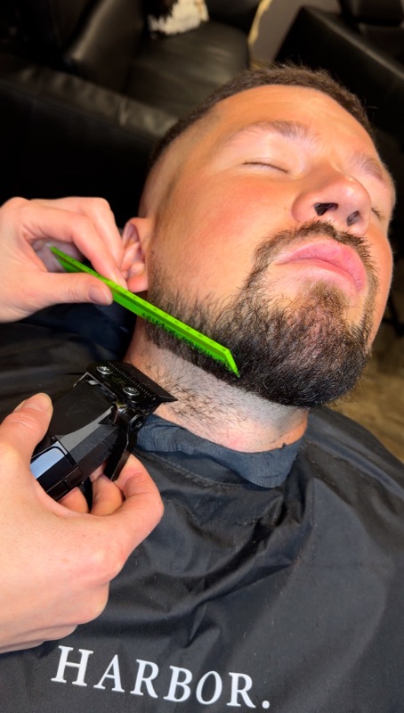 Майстер моделює бороду гребінцем і тримером